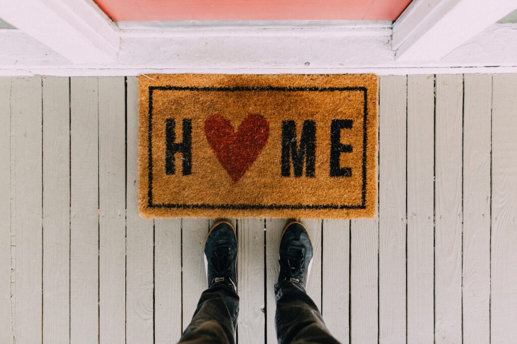 a welcome mat in front of a house that reads home